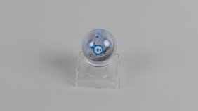 Der Sphero Mini Roboter auf einer transparenten Halterung vor grauem Hintergrund.
