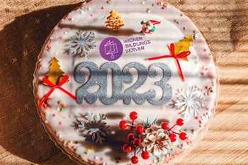 Eine Torte mit weihnachtlichen Motiven und dem Aufdruck "2023", zudem auch das Logo des Wiener Bildungsservers